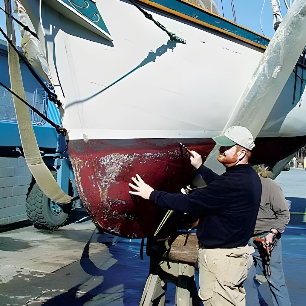 A man looking at barnacles on a boat hull